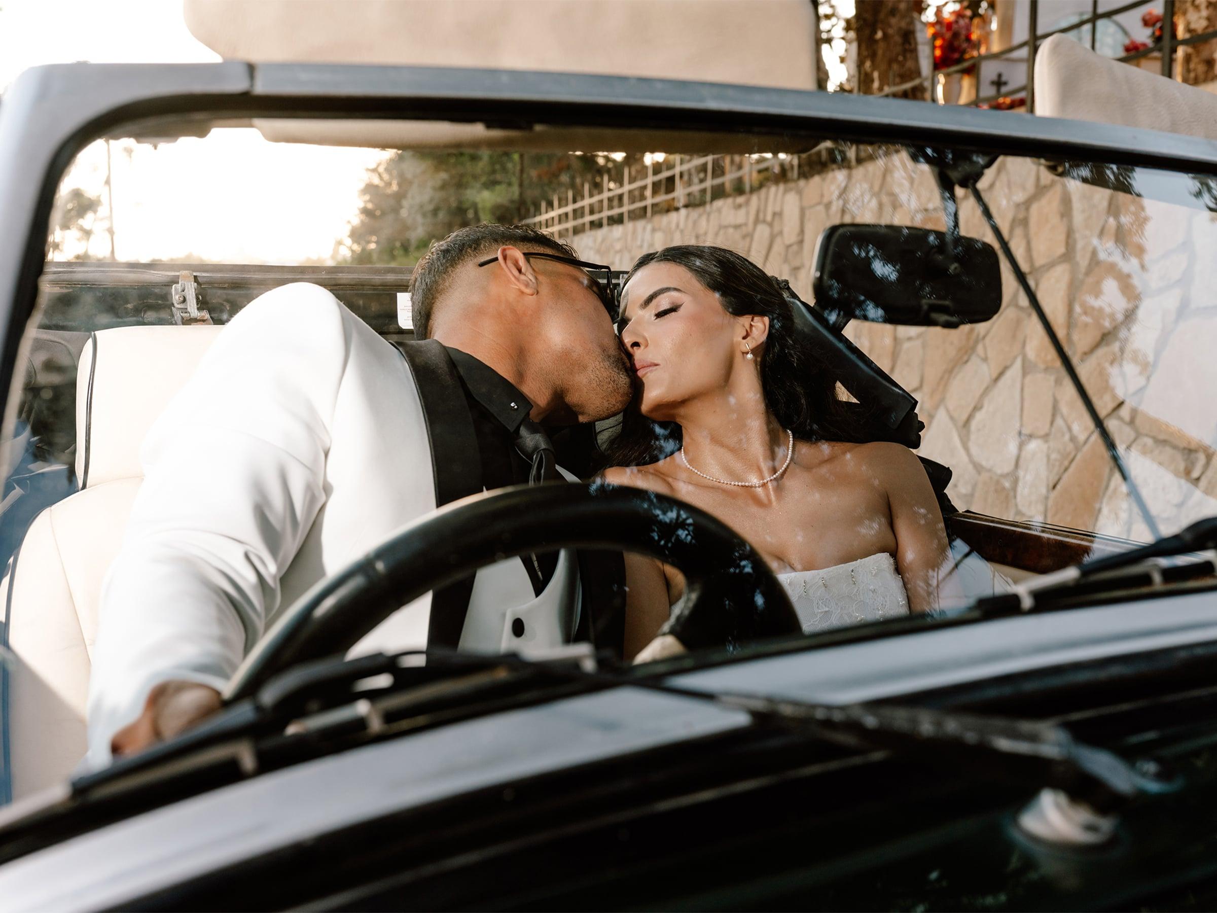 Bride and groom sharing a moment in a classic car
