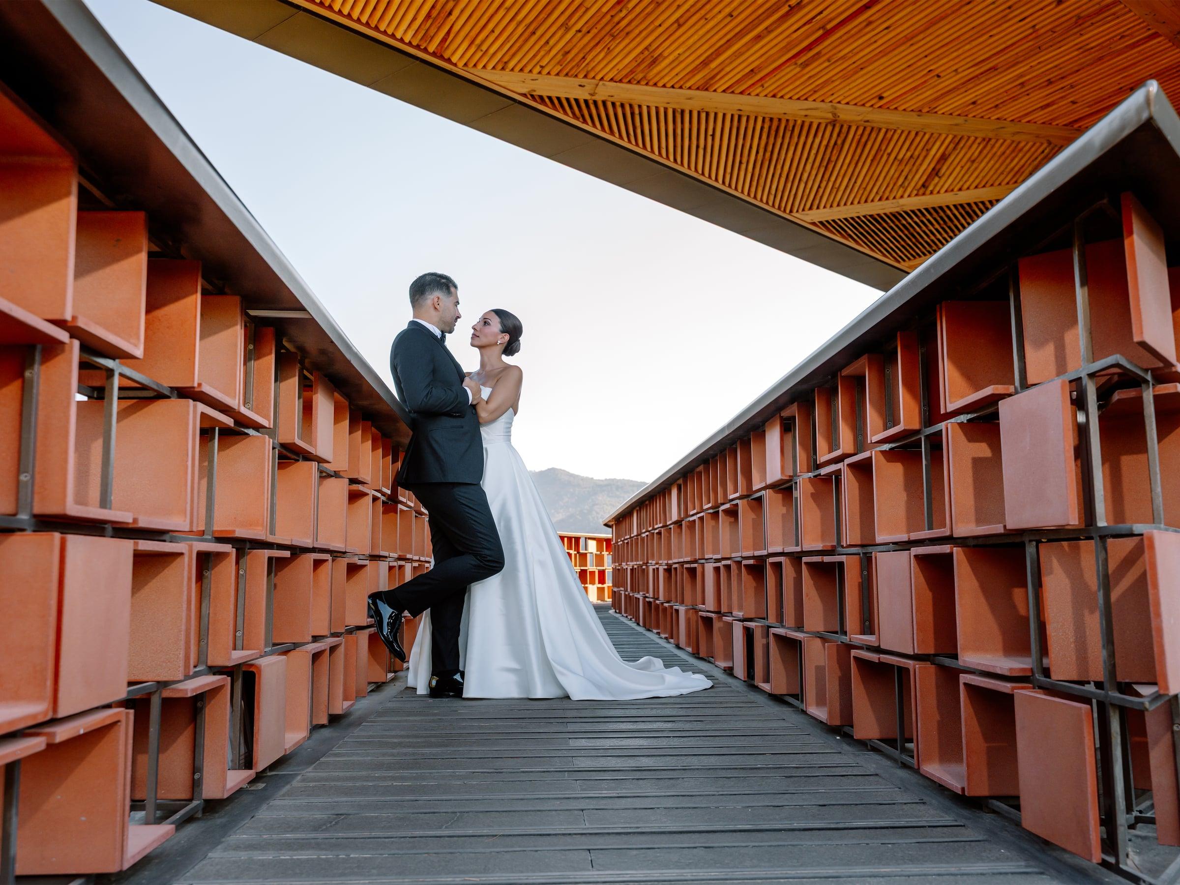 Bride and groom sharing a moment beneath a striking rooftop